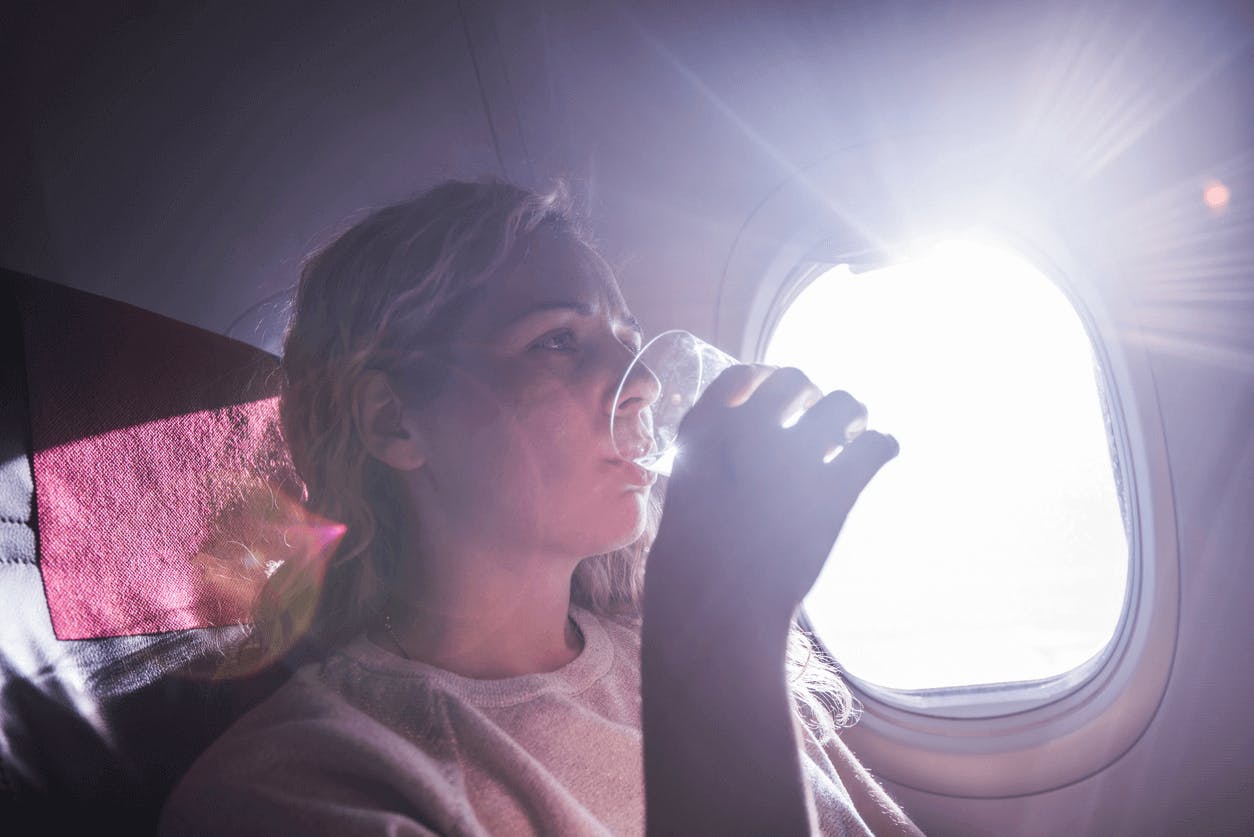 Hold dig hydreret. kvinde på fly drikker vand
