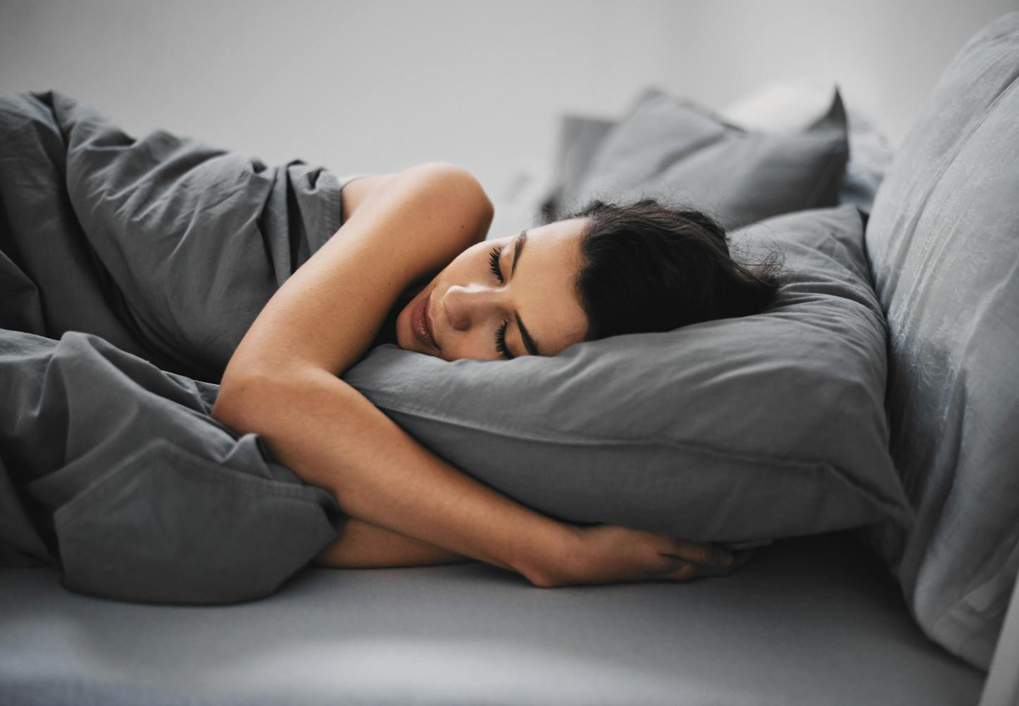 Kvinne sover i senga