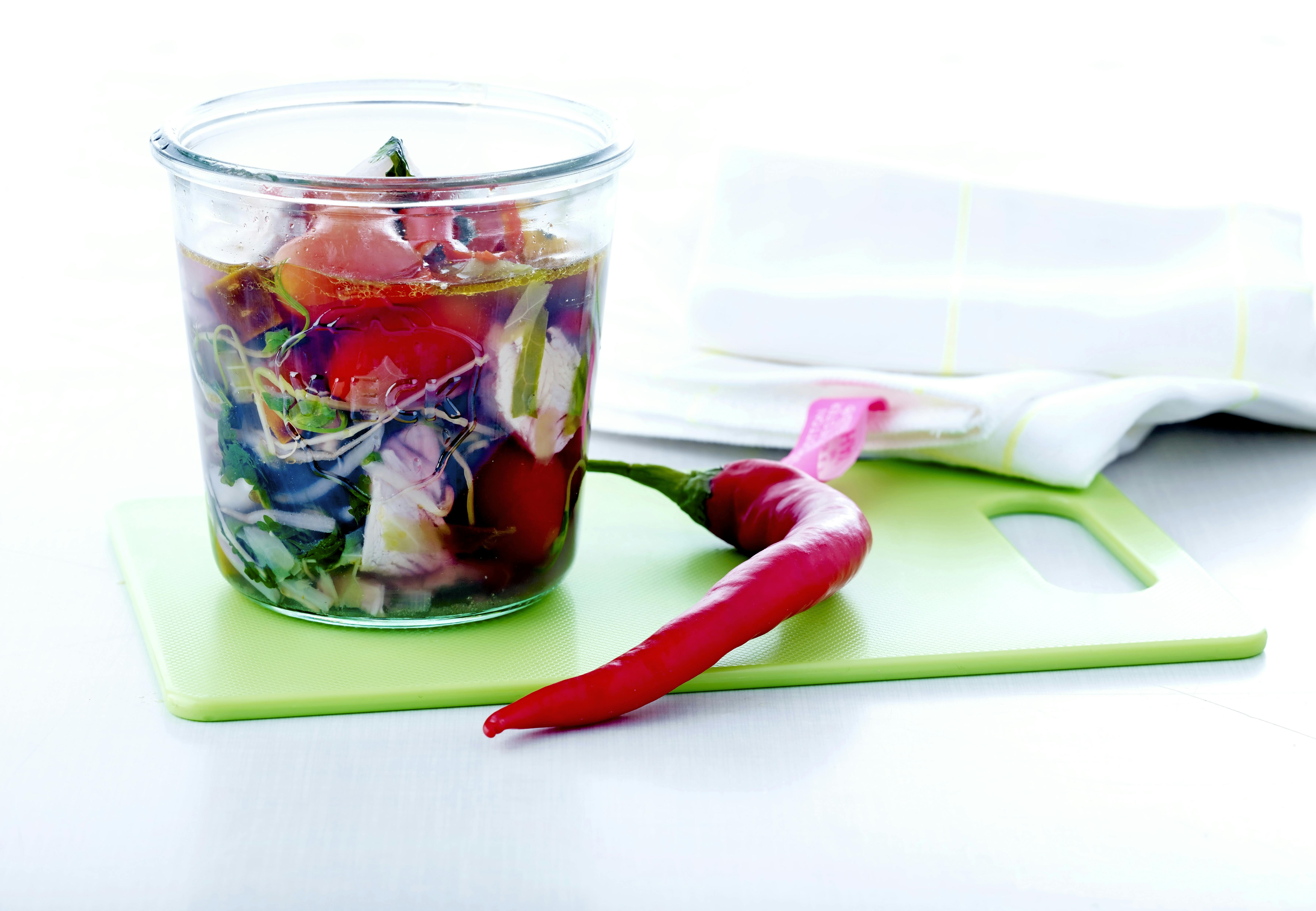 Skål med suppe og skærebræt med chili
