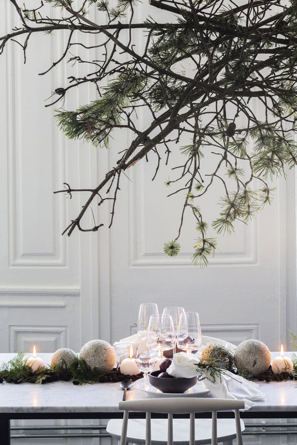 BOVEN DE TAFEL hangt een ‘wolk’ in Scandinavische stijl van dennentakken met en zonder naalden. Schalen en glazen van Ikea en bestek van H&M Home BOVEN DE TAFEL hangt een ‘wolk’ in Scandinavische stijl van dennentakken met en zonder naalden. Schalen en glazen van Ikea en bestek van H&M Home