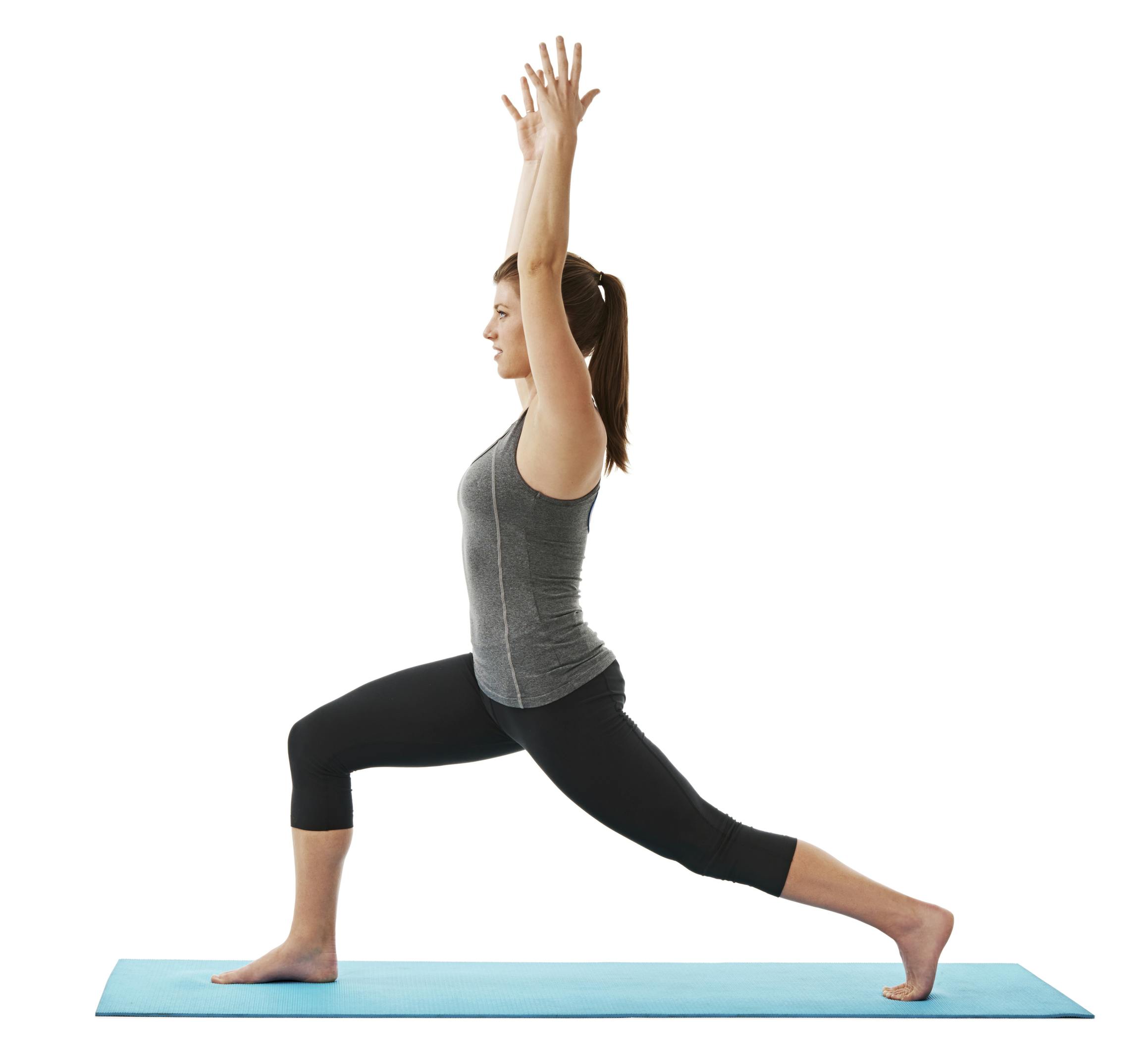 Kvinde står i en lunge på en yogamåtte