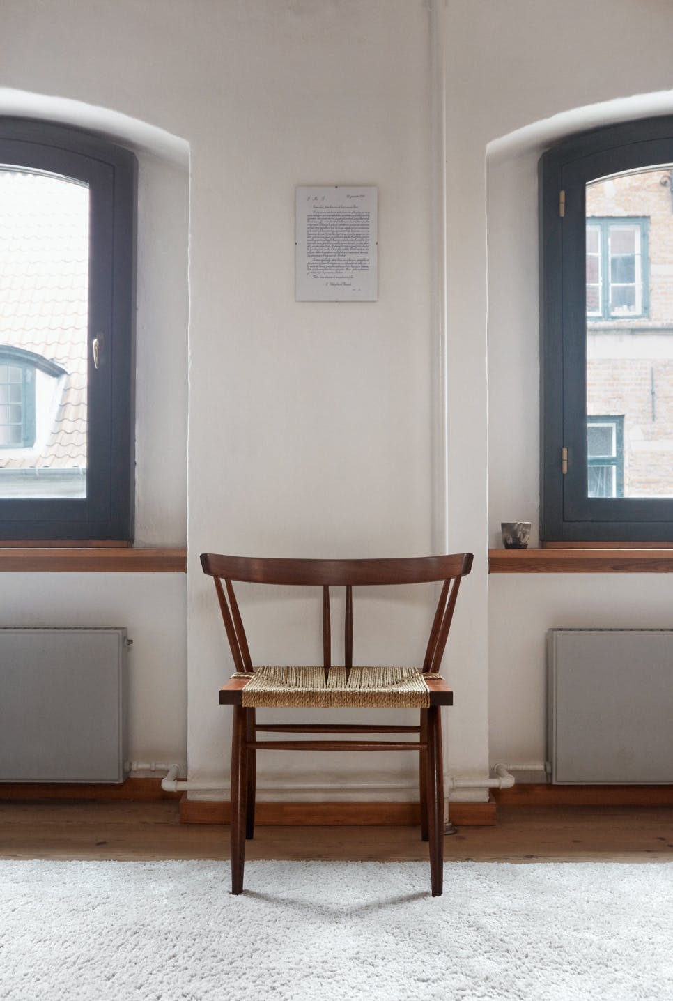 Een stoel van de Amerikaans-Japanse meubelmaker en architect George Nakashima. Mathias kocht de stoel van diens dochter in Pennsylvania. wooden George Nakashima chair with rug