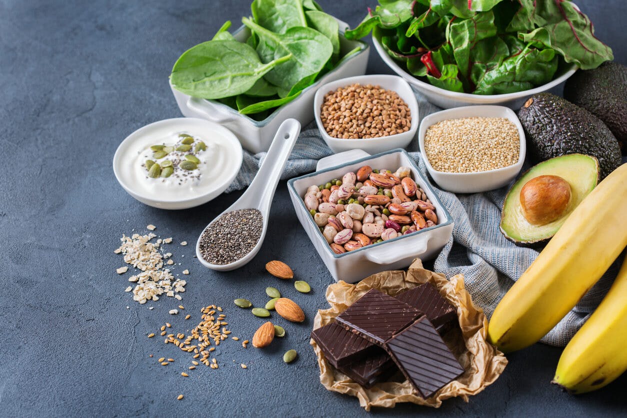 Få ekstra magnesium gennem kosten. bælgfrugter, nødder, mørk chokolade og gryn arrangeret på bord