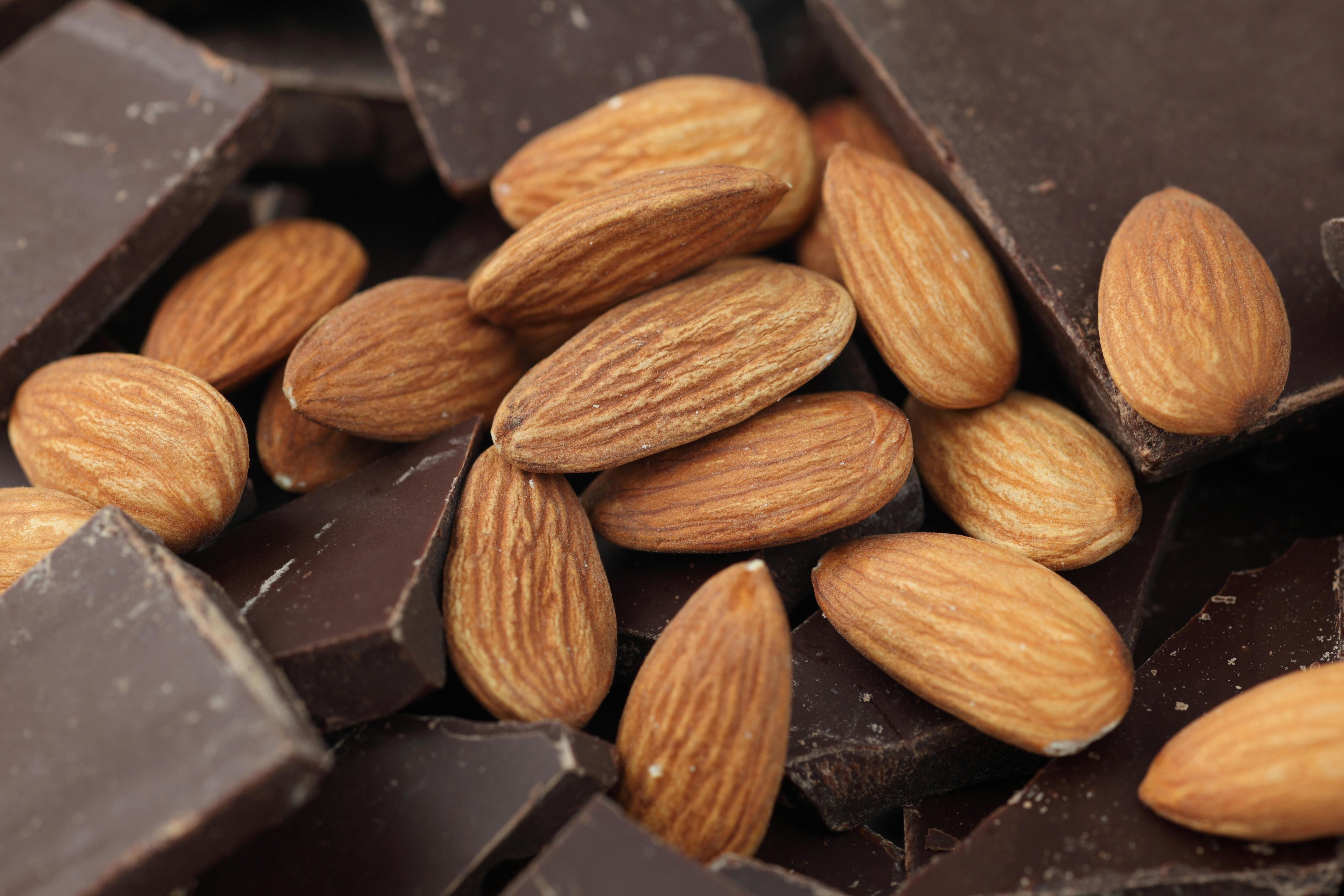 Snup en håndfuld mandler og mørk chokolade. Mandler og mørk chokolade