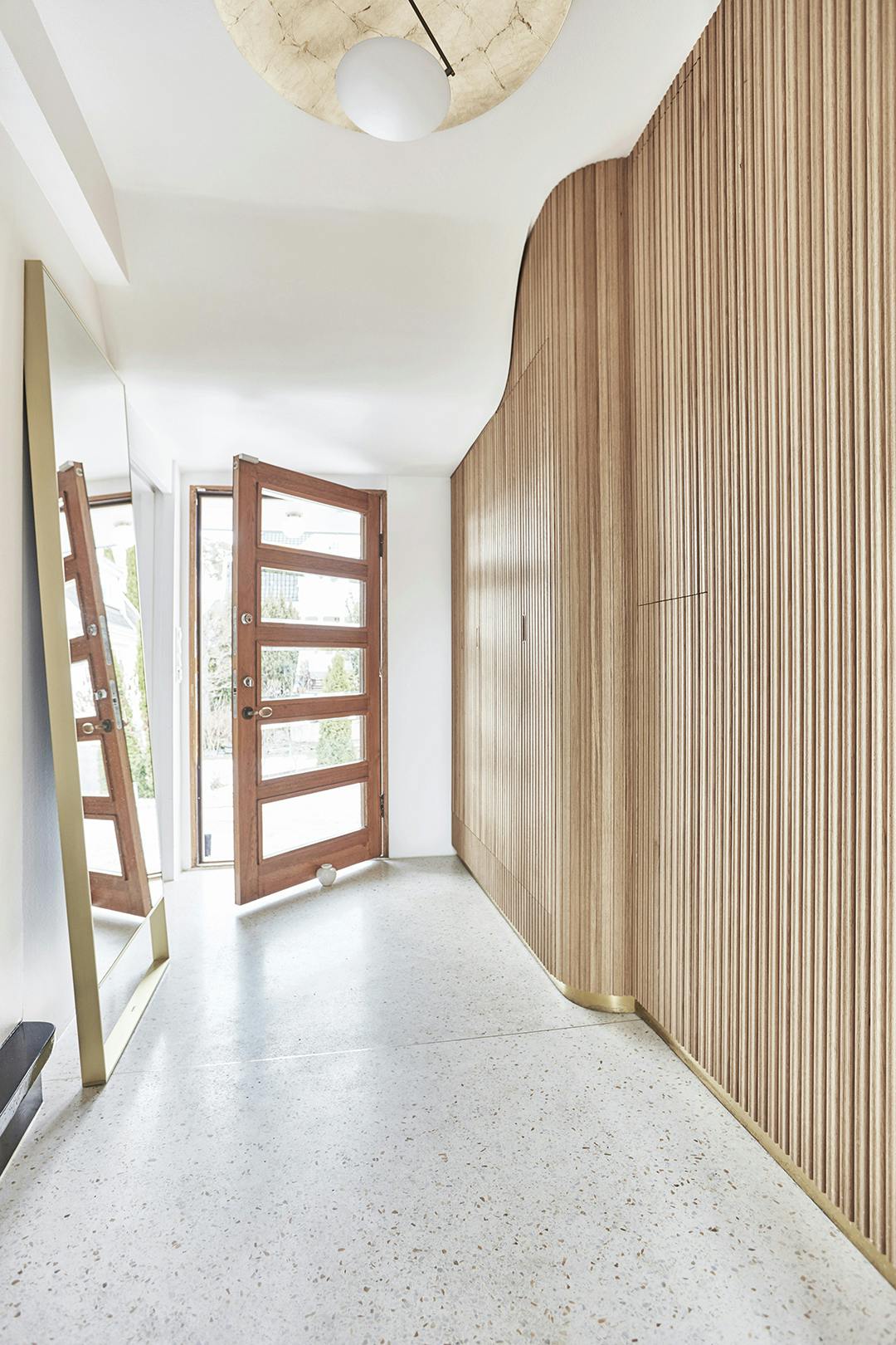 De entree doet haast denken aan een modern museum. Terrazzo entree, spiegel van B&B Italia.