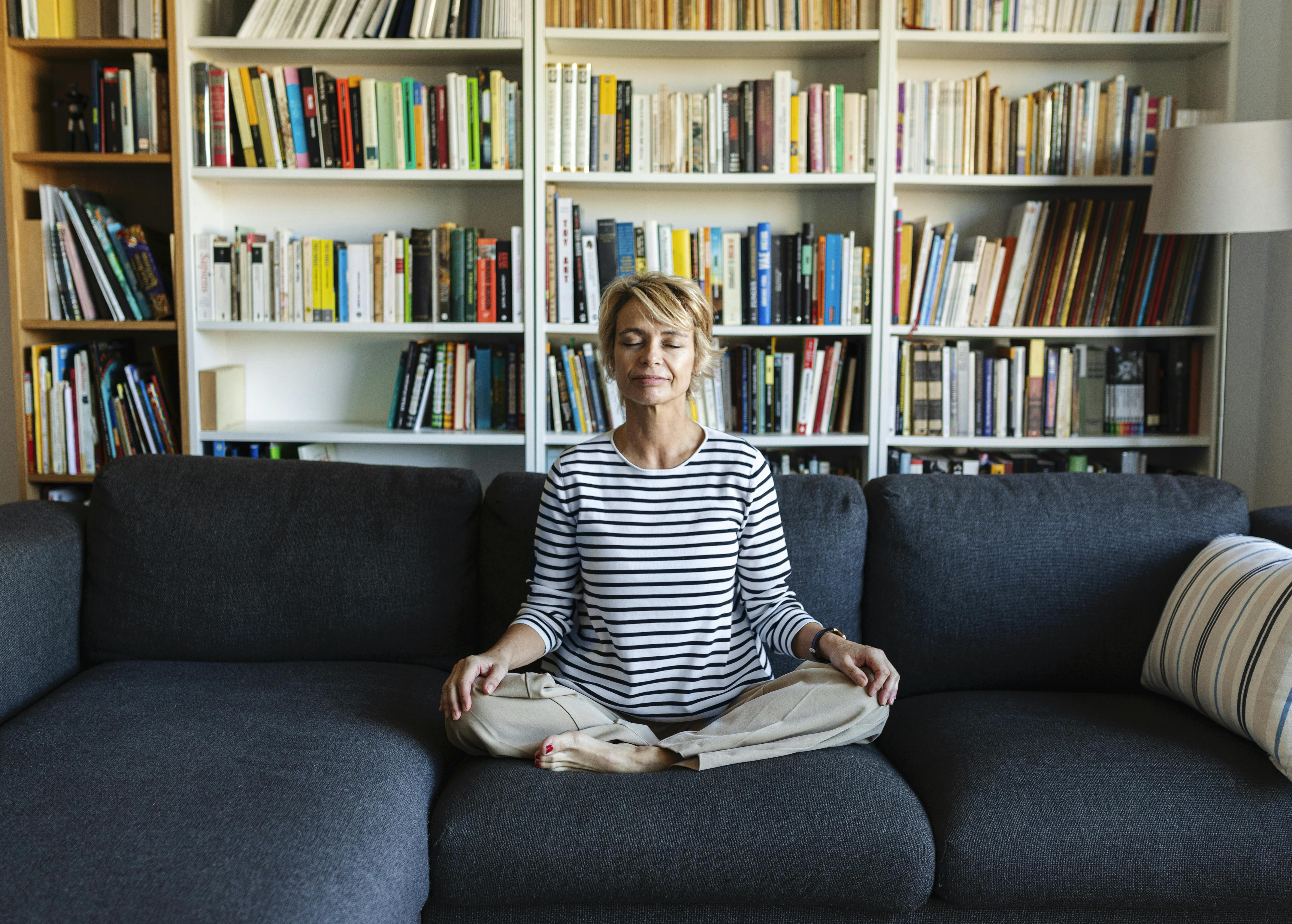 Har du overvejet, om mindfulness er noget for dig? Kvinde mediterer i en sofa