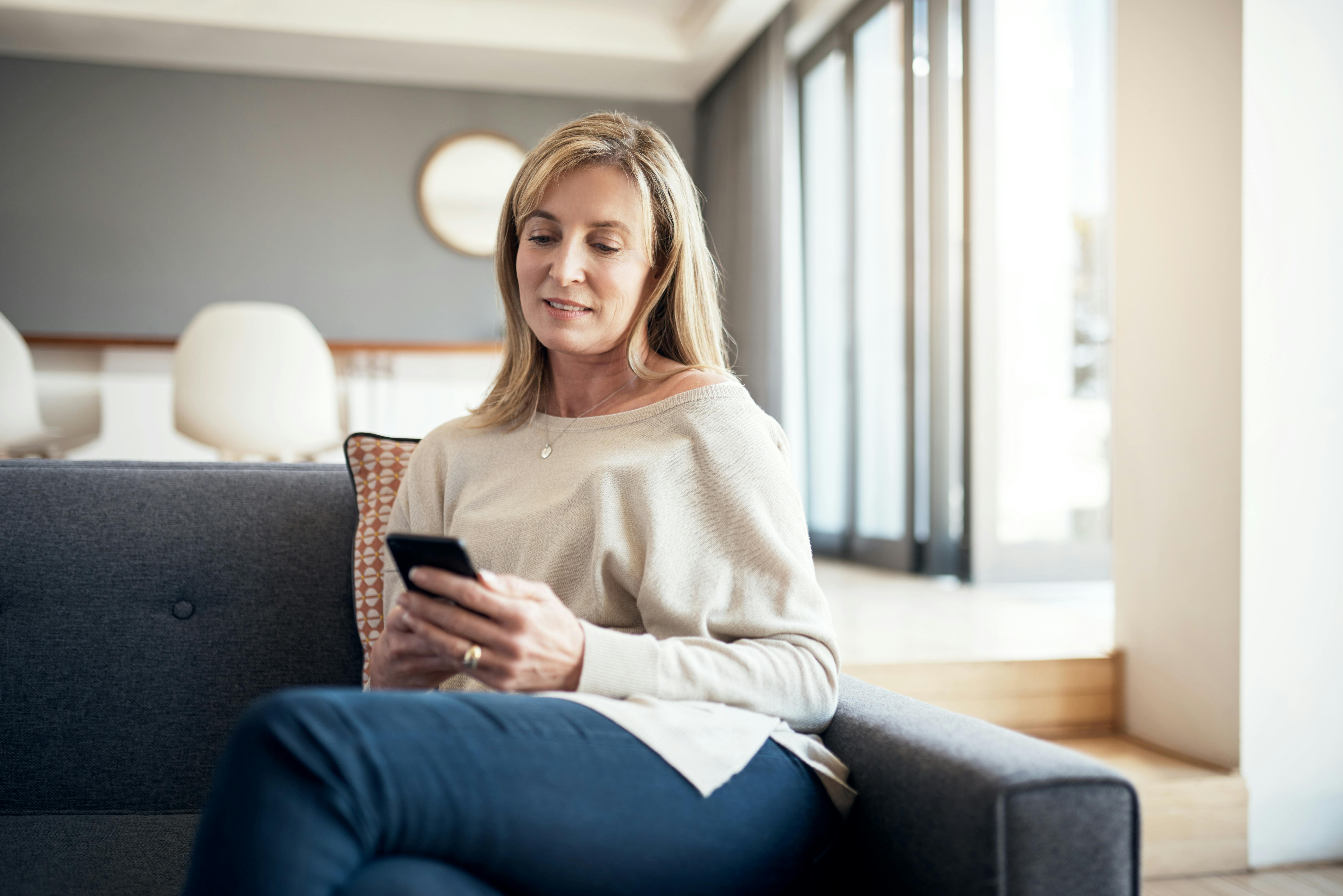 Tag et tjek på, hvor meget tid om dagen du bruger på din telefon. Og skab digitale frizoner for dig selv. Kvinde tjekker sin mobil