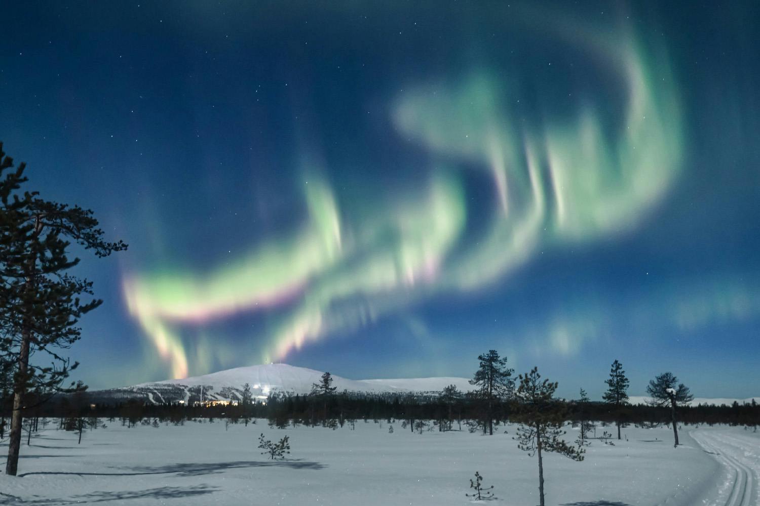Nordlys over snøkledd landskap.