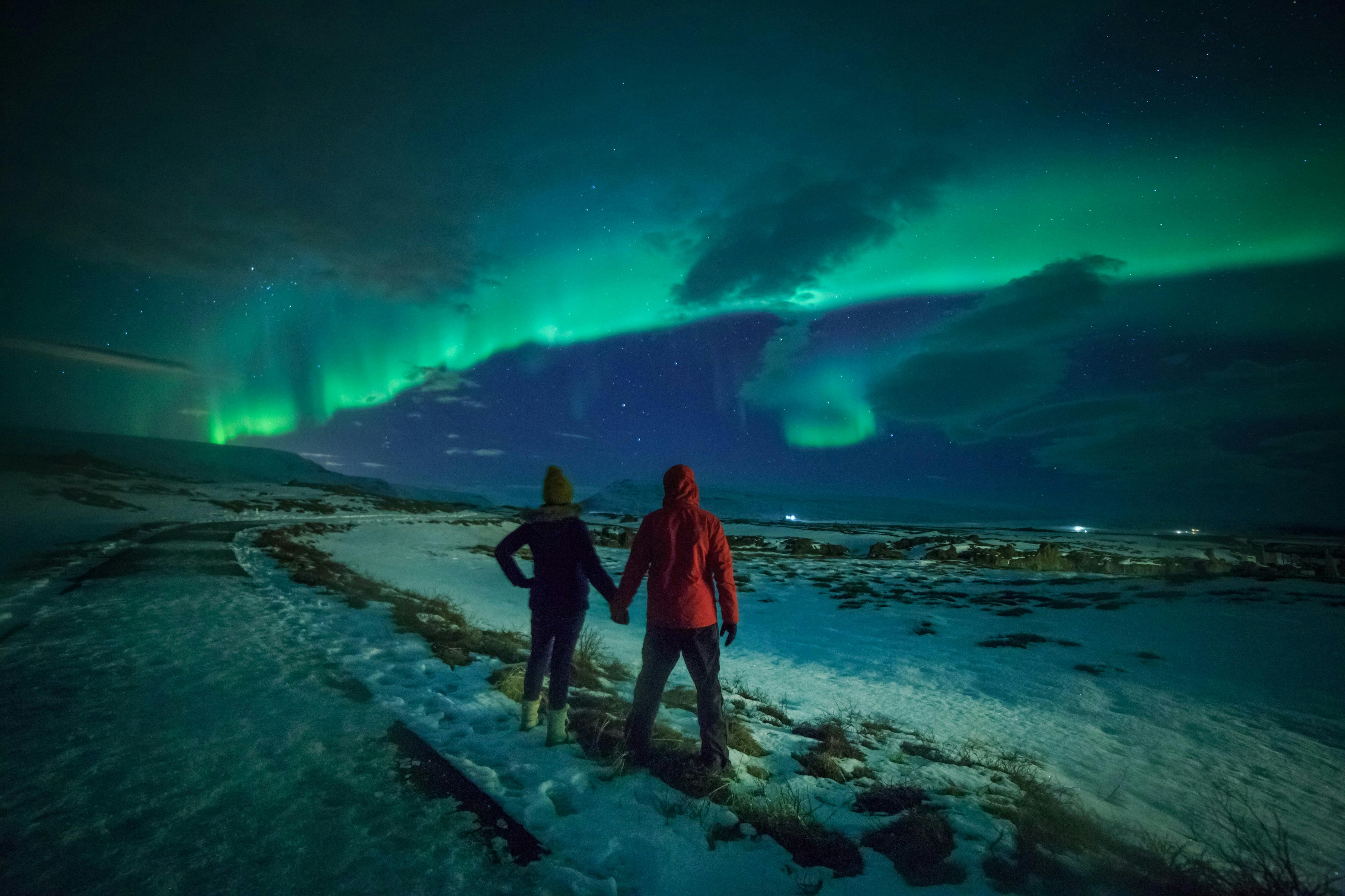 Kærestepar ser på nordlys.