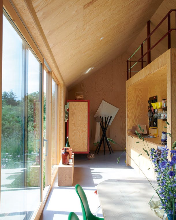 Vrij uitzicht is een terugkerend element in het huis, dat één open ruimte is. kleurrijke houten keuken met betonnen gietvloer