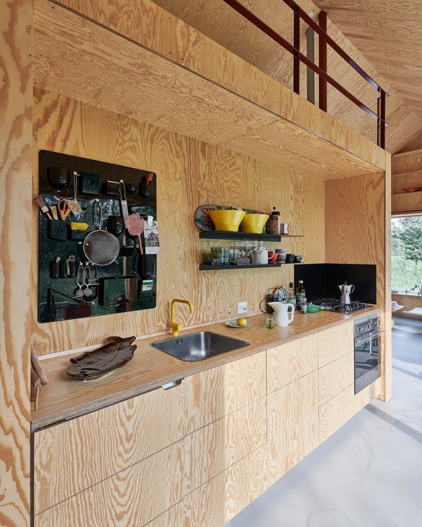 de lichte, discrete keukennis is door Karen ontworpen. Achter de fronten is een koelkast van Smeg ingebouwd. Het opbergmeubel Uten.Silo is in 1969 door Dorothee Becker ontworpen voor Vitra. houten keuken met smeg apparatuur