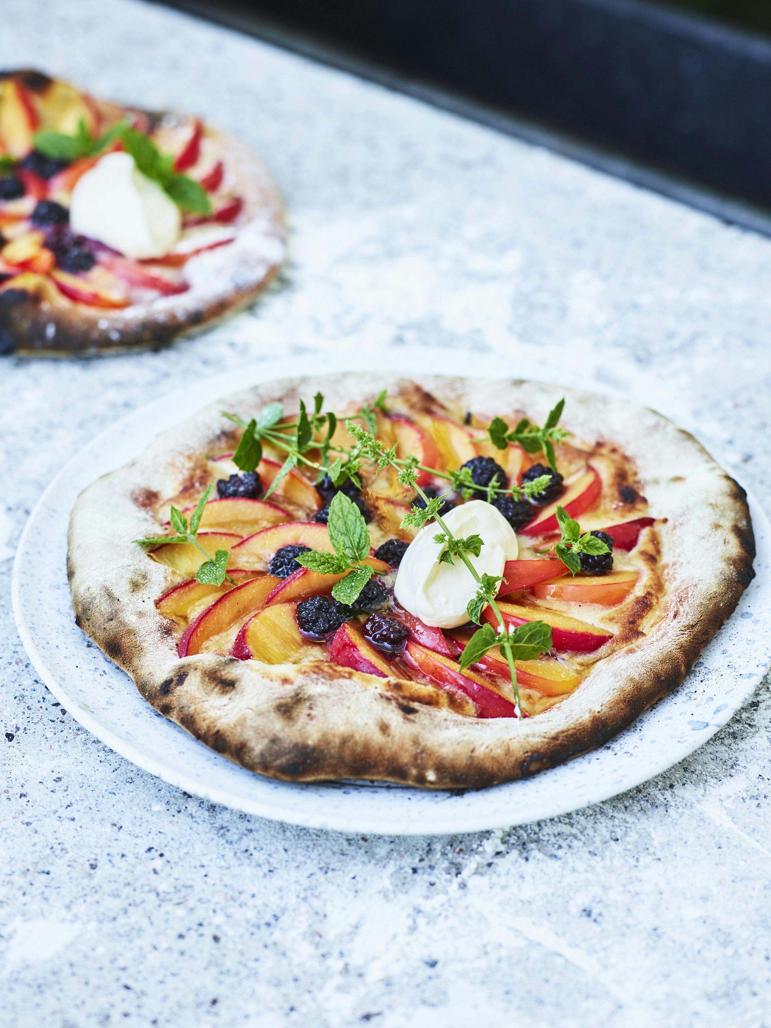 En frisk og sød dessertpizza. Pizza med brombær og blomme