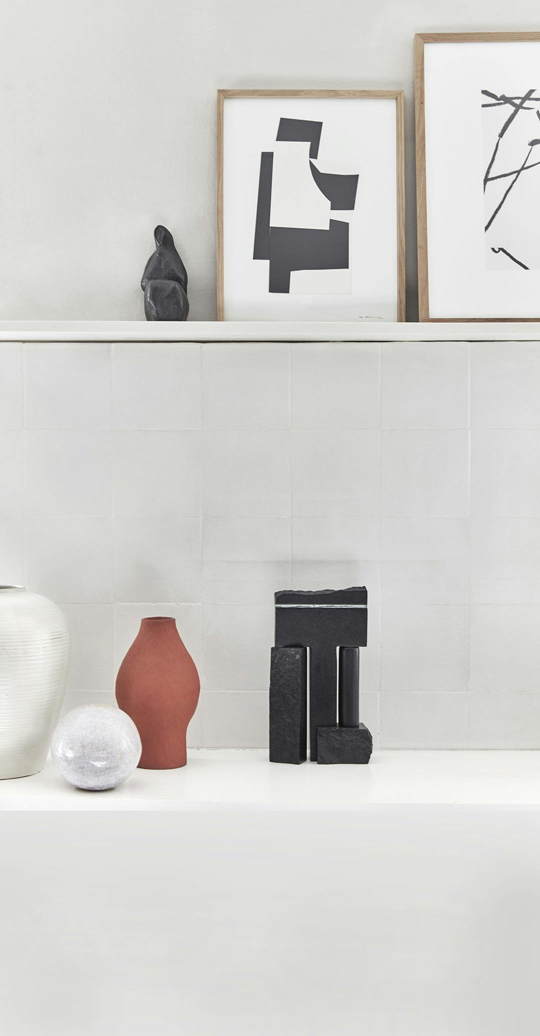 Decoratieve tableaus komen op veel plekken in het appartement terug, zoals hier, waar eigen werk zij aan zij staat met door Sara geselecteerde objecten. Tegelwand met keramiek, Japanse stijl.