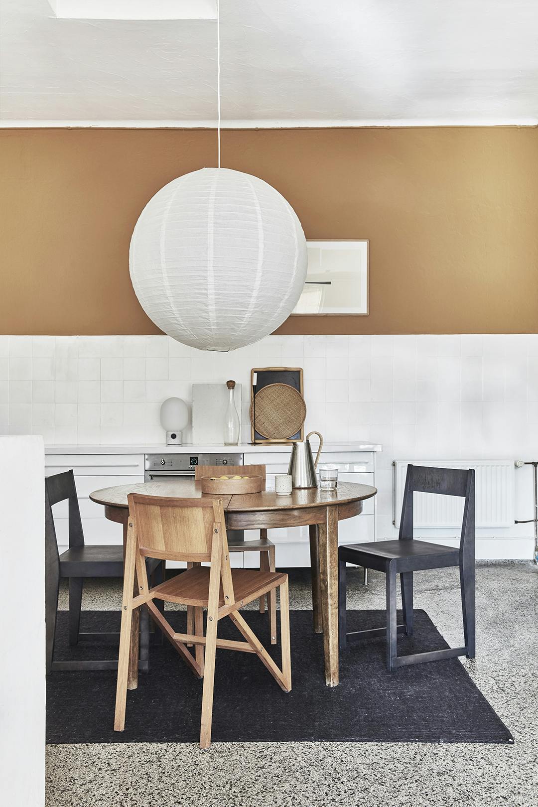De eettafel heeft Sara geërfd, de zwarte stoelen zijn van Frama, en de lichte zijn vintage van Established & Sons. Sara wil dat haar meubels een leven lang meegaan en niet slechts een trend volgen. Frama stoelen, vintage Established & Sons stoelen aan ronde eettafel.