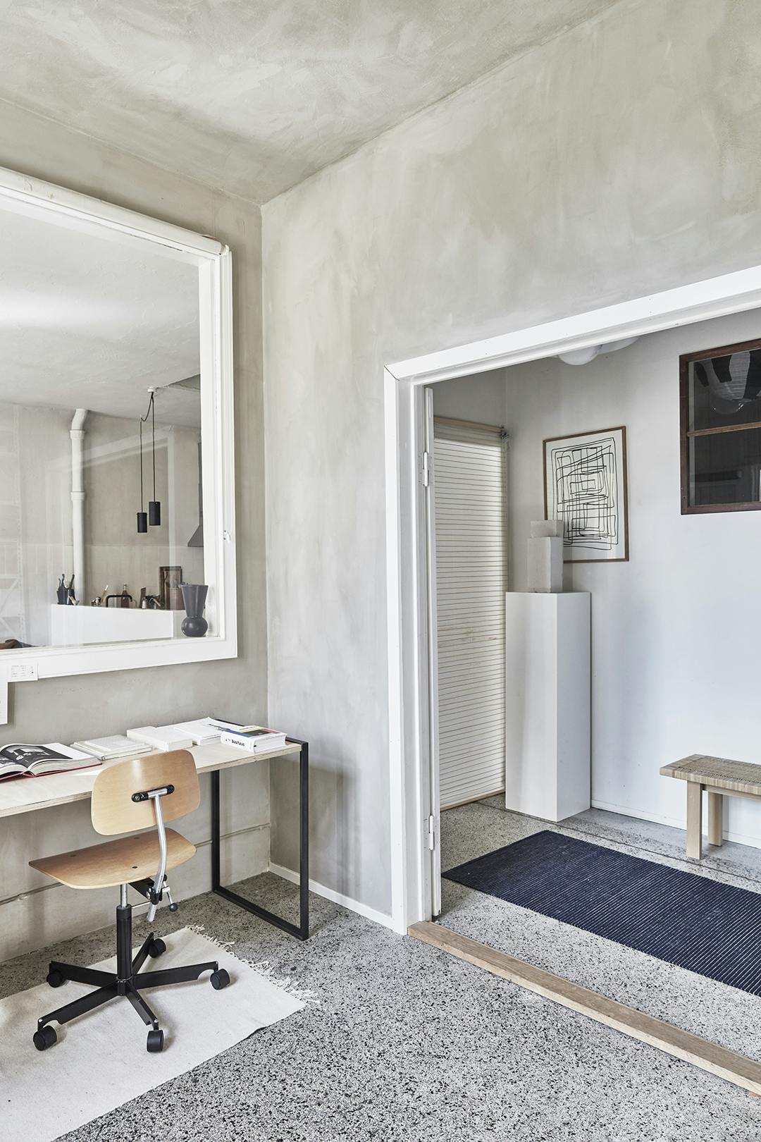 Vanuit de studio zie je alle andere ruimtes, zodat je ook daar bij de anderen betrokken bent. Atelier Cph werkruimte met binnenraam en vintage bureaustoel.