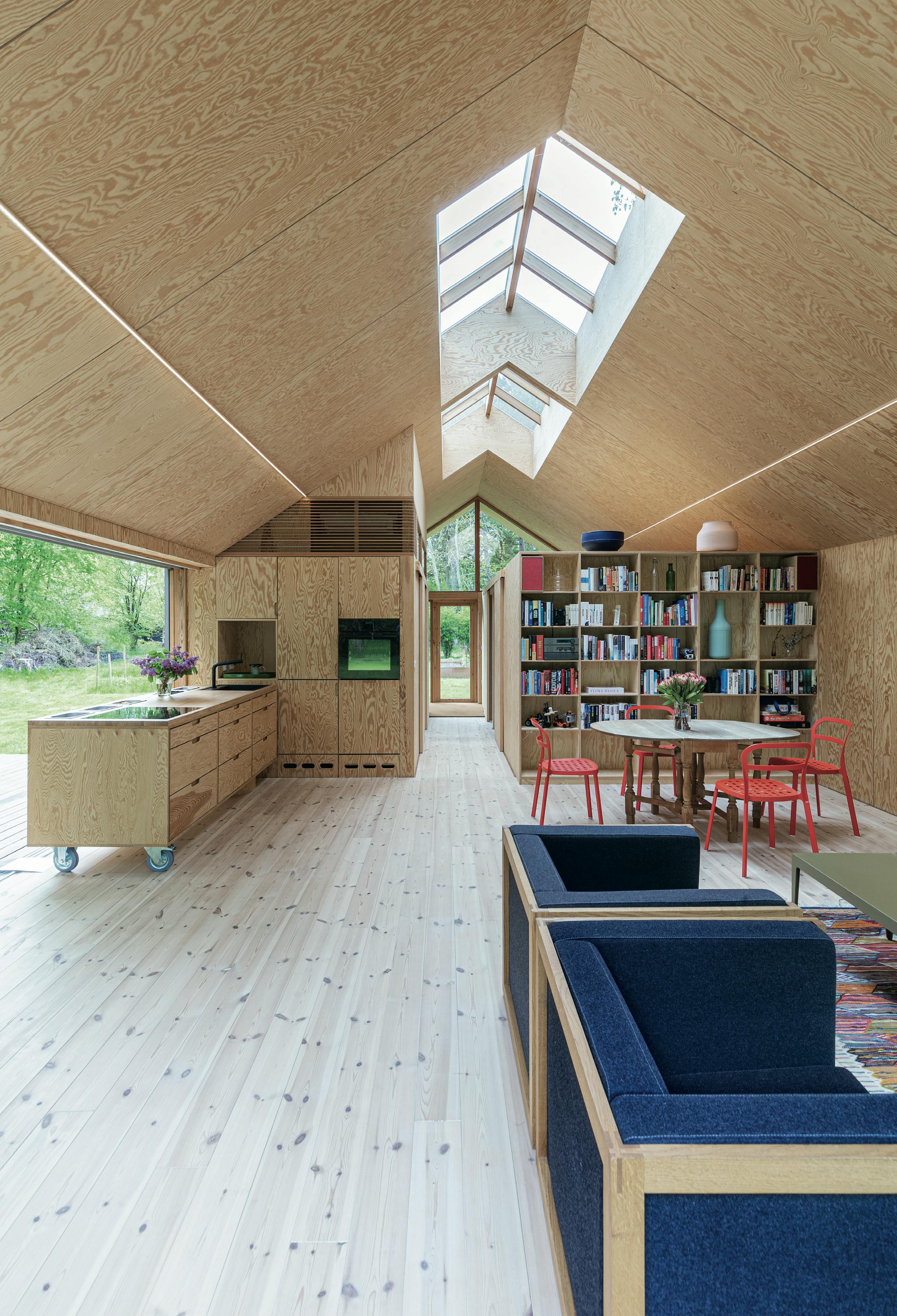 Hier staan eindeloos veel boeken, want volgens Jens-Christian horen vakantie en lezen bij elkaar. houten huis met dakramen en scandinavische uitstraling