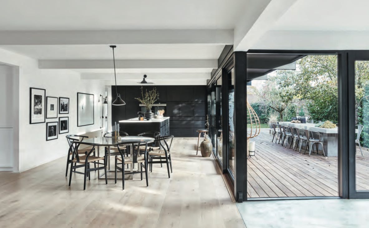 DE RONDE EETTAFEL is Poul Kjærholms PK54 met bruin marmeren blad van Fritz Hansen. Ronde eettafel, marmer blad en zwarte stoelen.