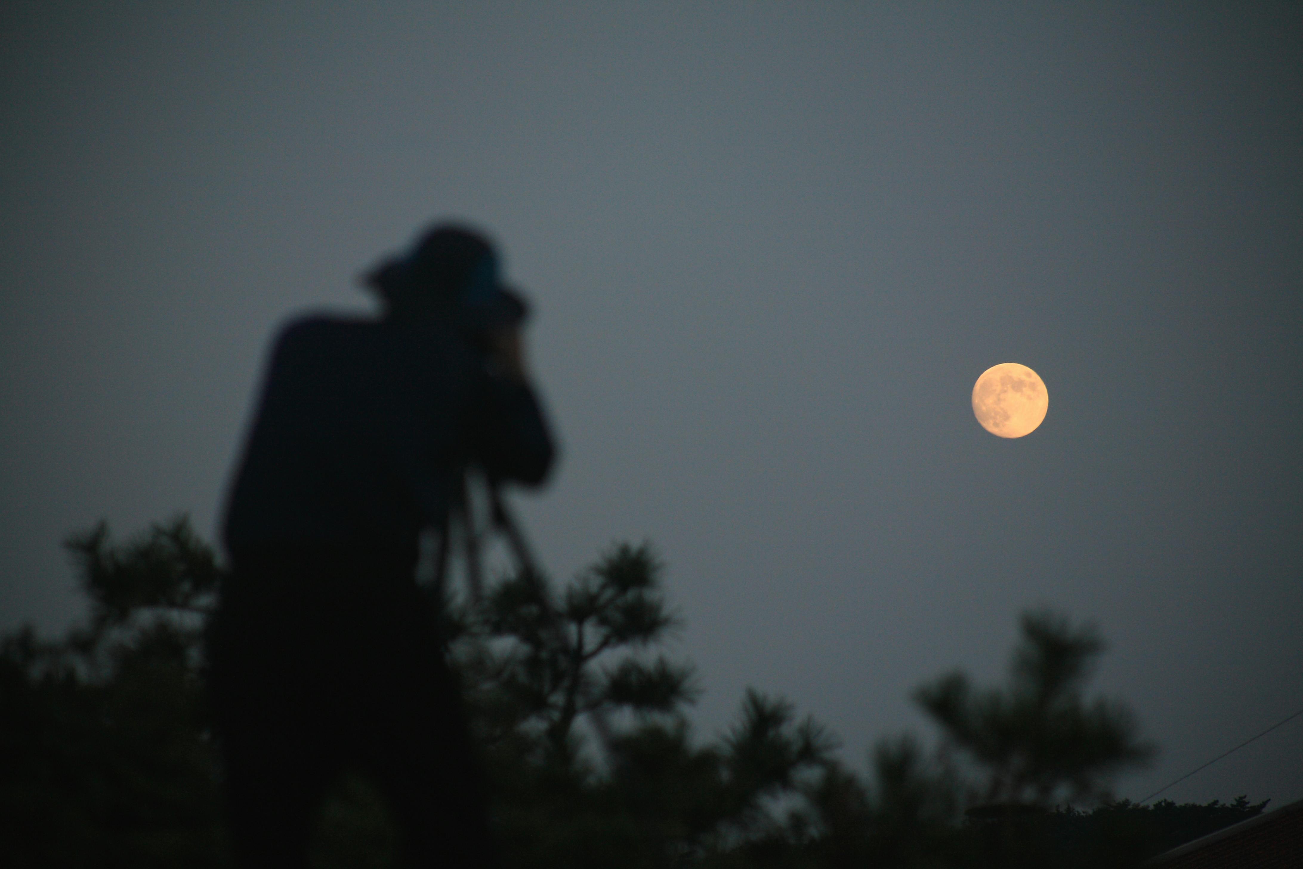Mann fotograferer supermånen