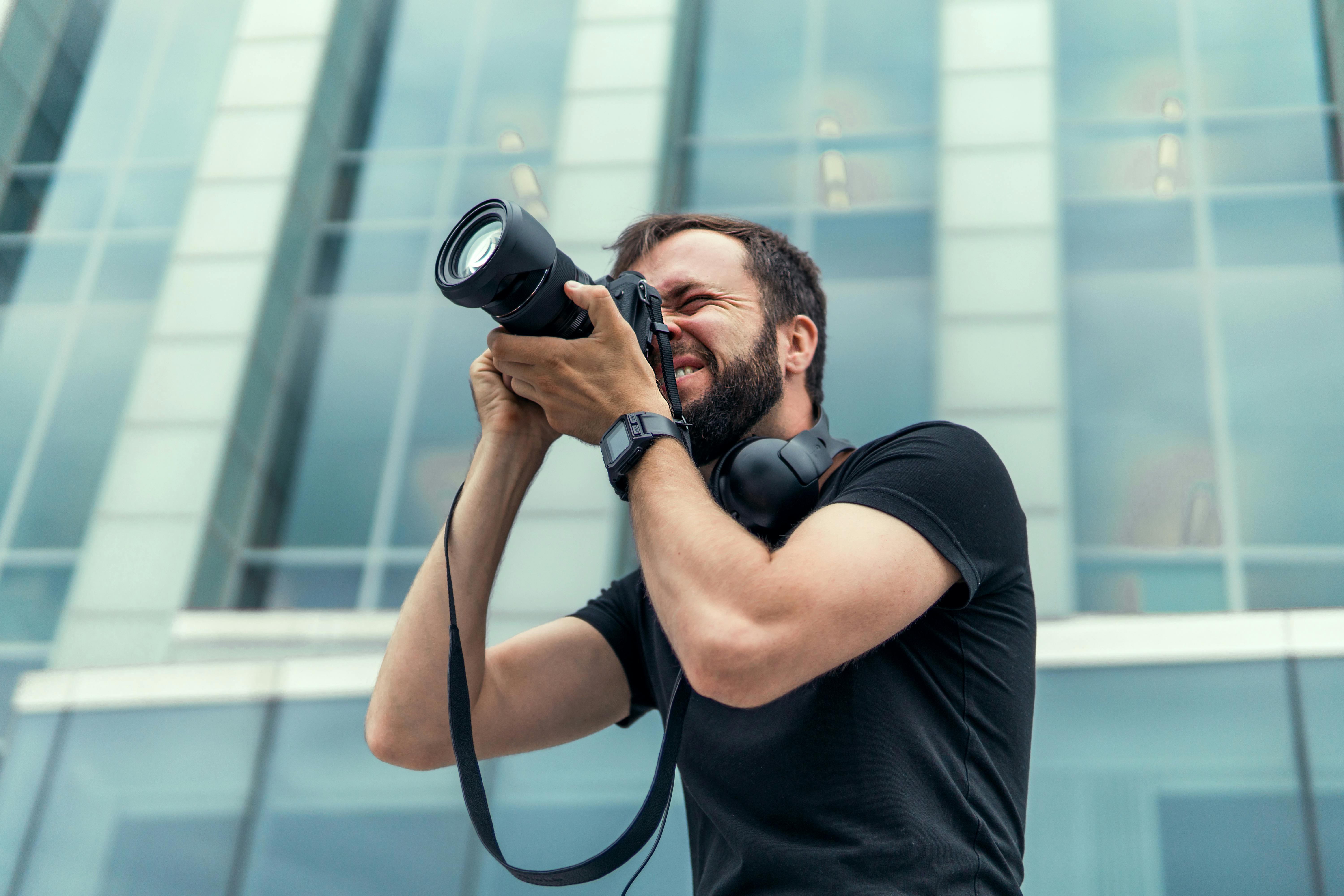 Mand fotograferer foran glasbygning