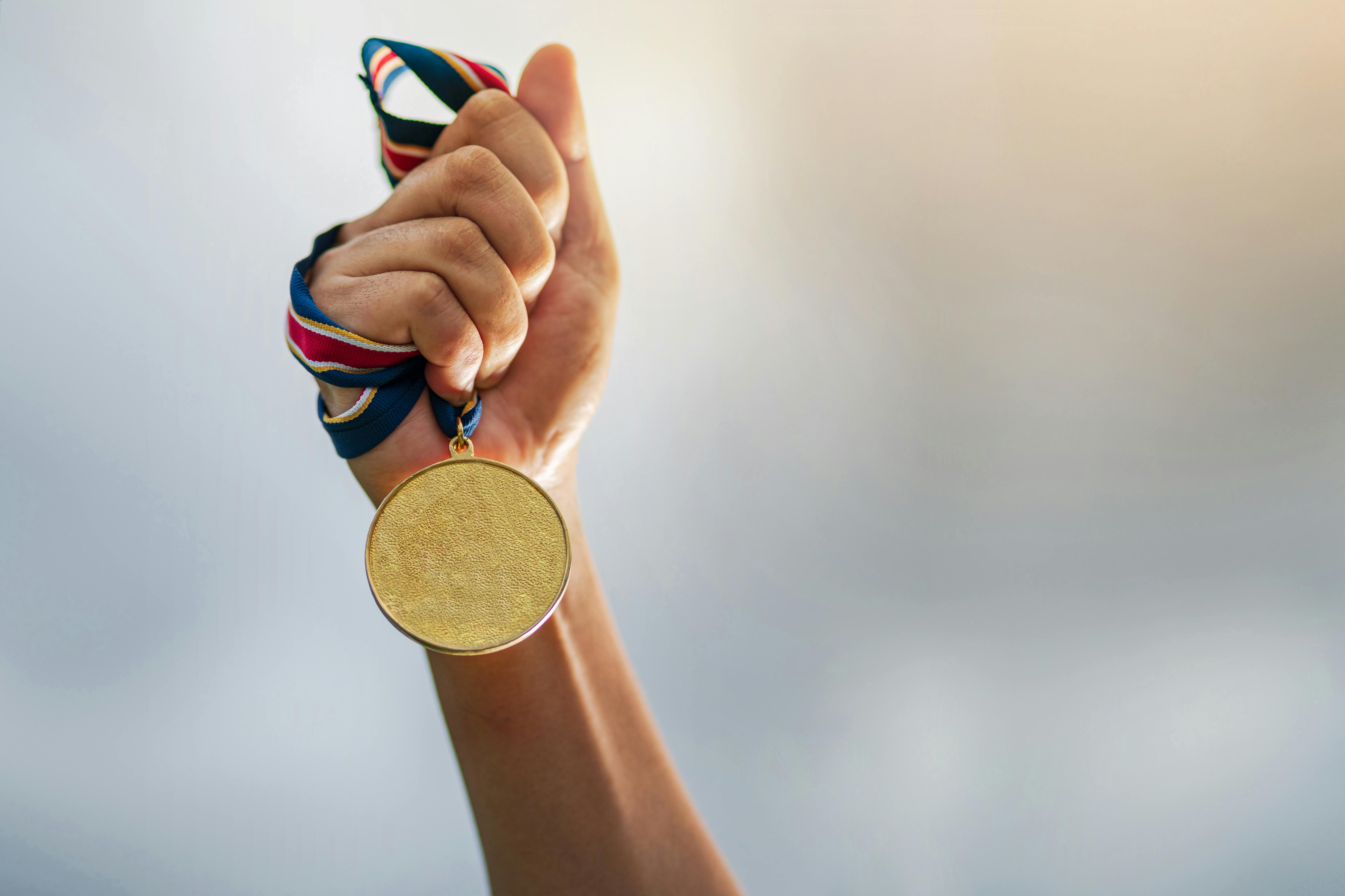 En man håller upp en medalj