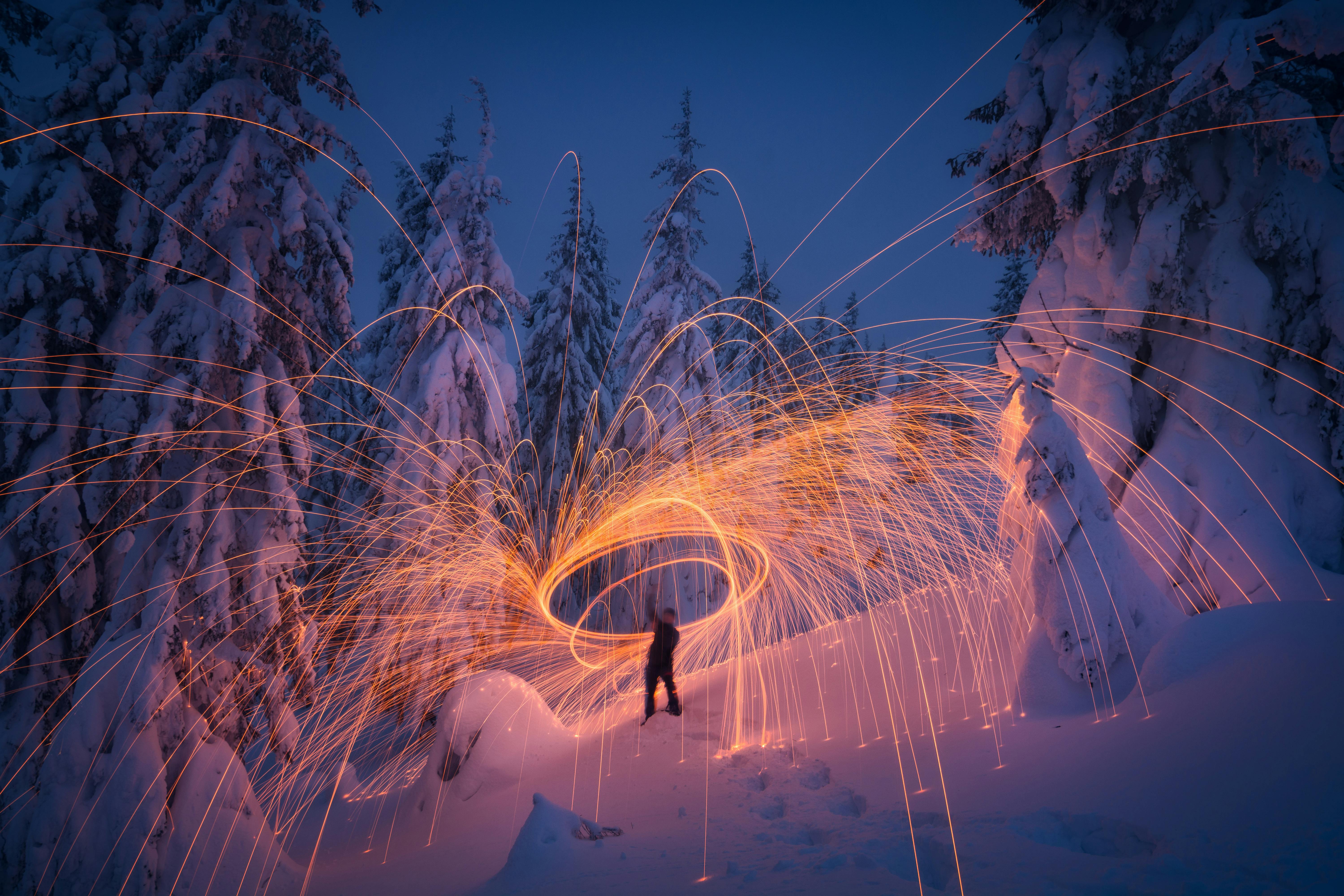 Gnister rundt personer i snø i skogen