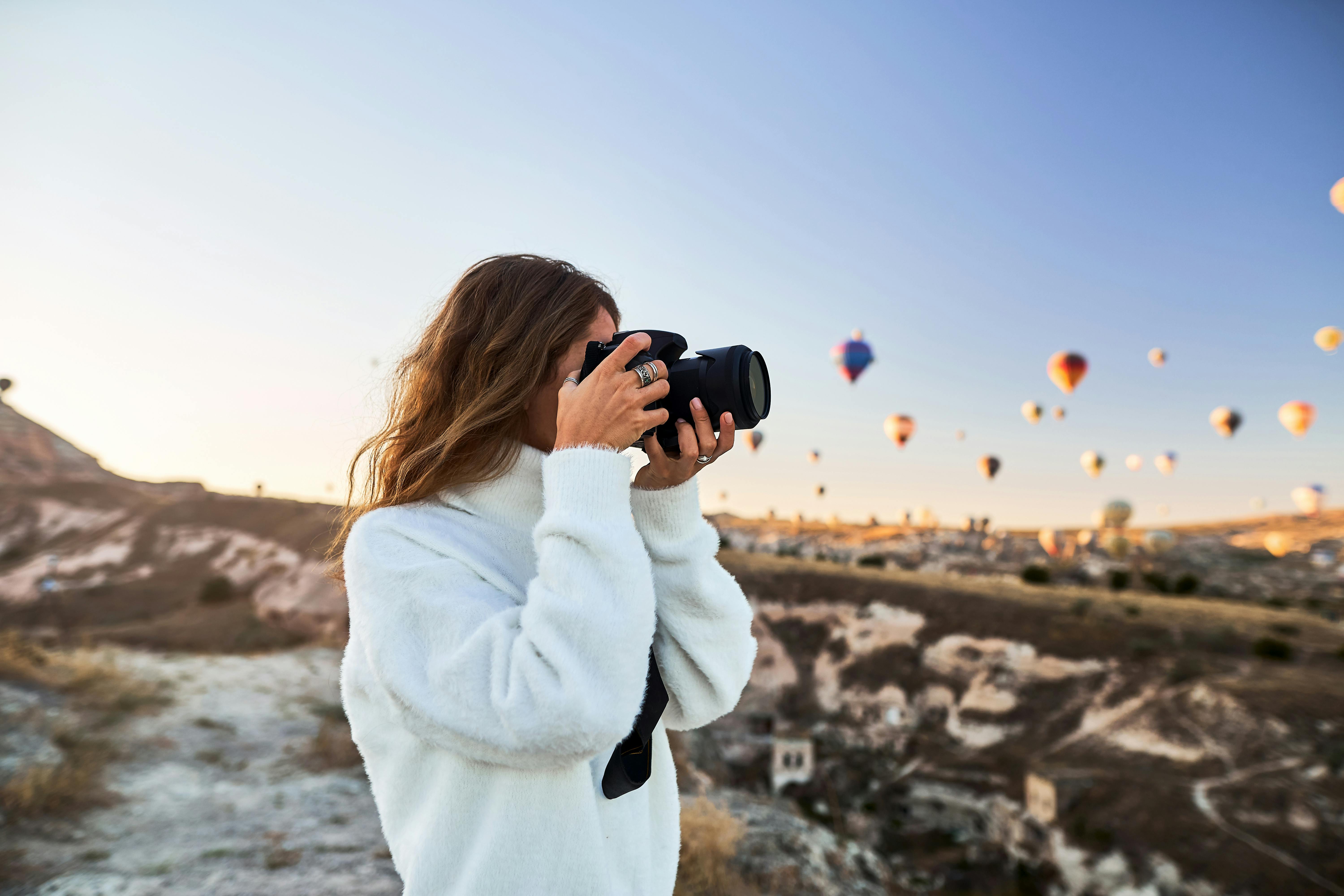 Kvinna fotograferar luftballonger.