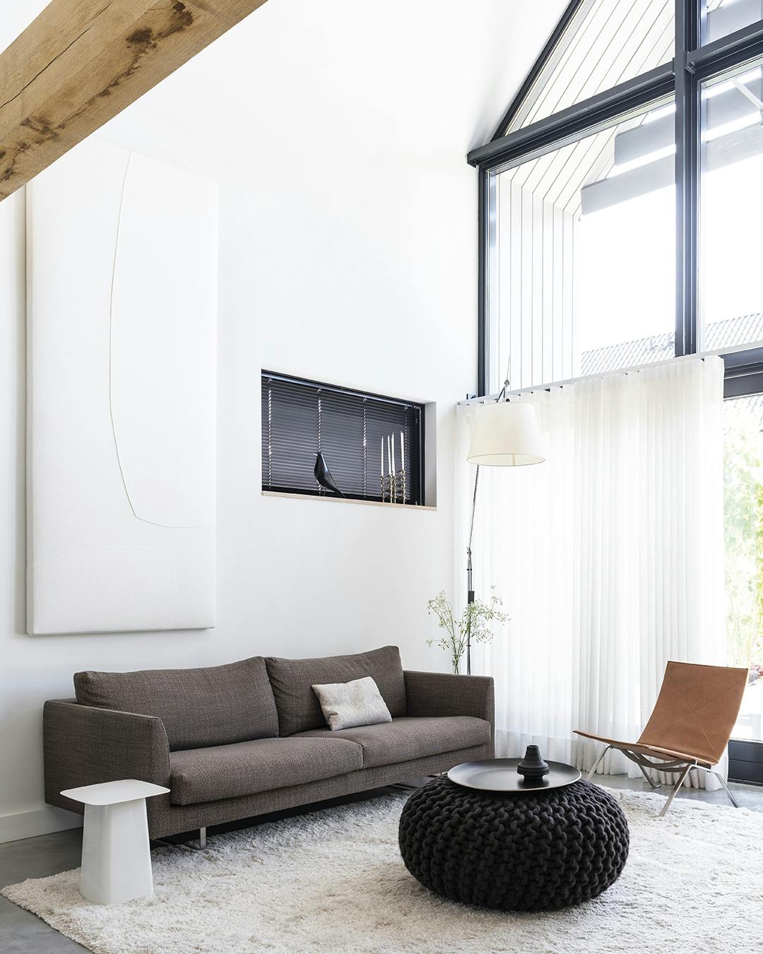 De woonkamer is heerlijk hoog en licht, en een akoestisch paneel van Mokko Amsterdam voorkomt dat de ruimte hol klinkt. De bank is van Axel van Montis, en de PK22 stoel is van Poul Kjaerholm/Fritz Hansen. Akoestisch paneel Mokko Amsterdam, Poul Kjaerholm Fritz Hansen stoel