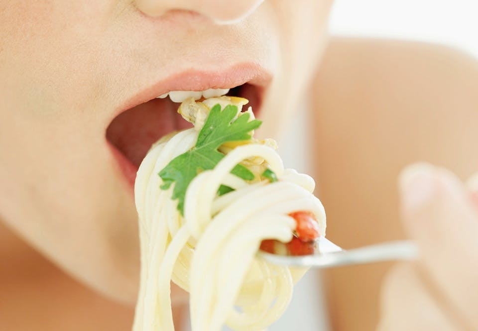 Nainen syö pastaa