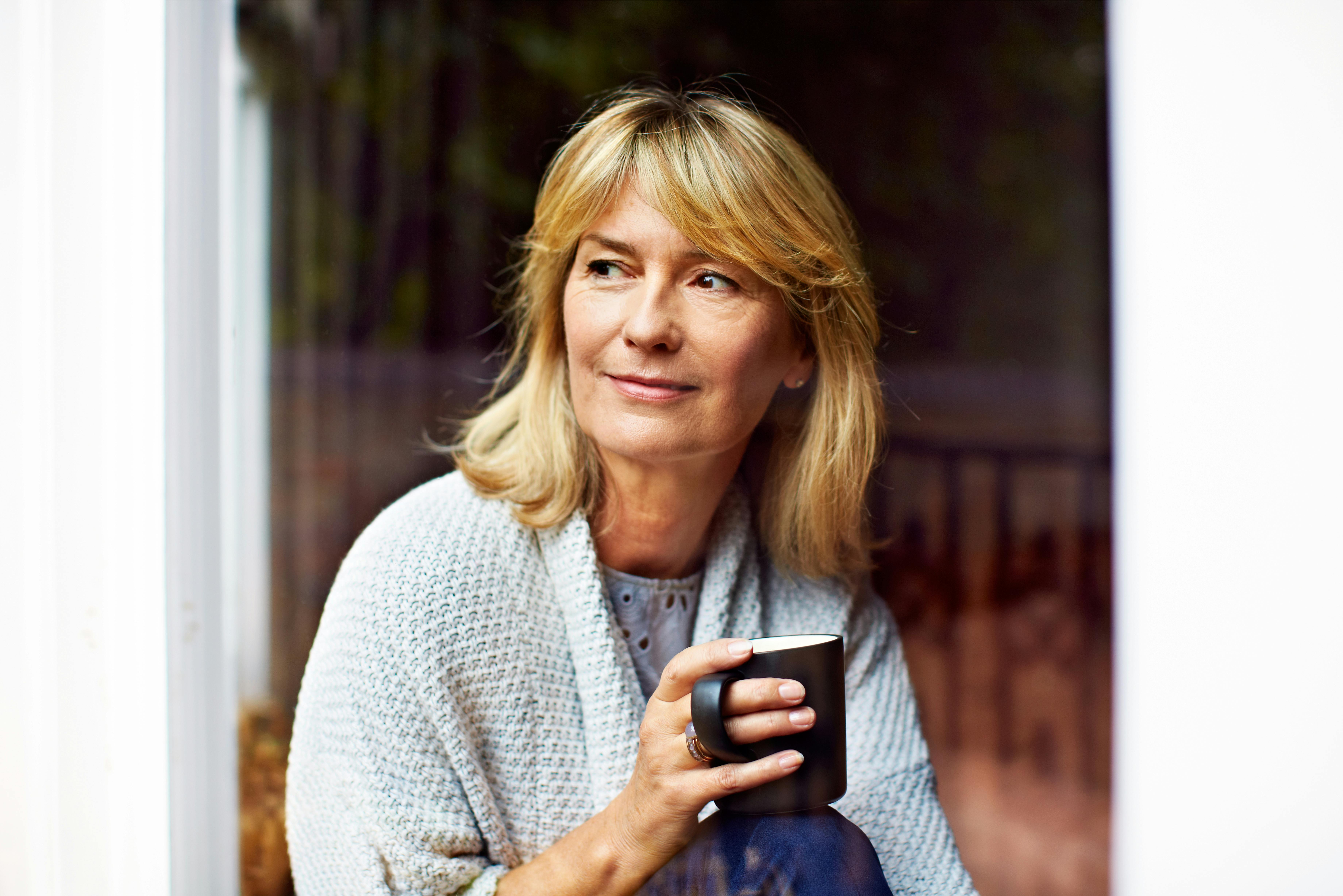 Alderskrisen er sjældent et emne, som kvinder diskuterer med andre. Gør du? Moden kvinde drikker kaffe og sidder og tænker