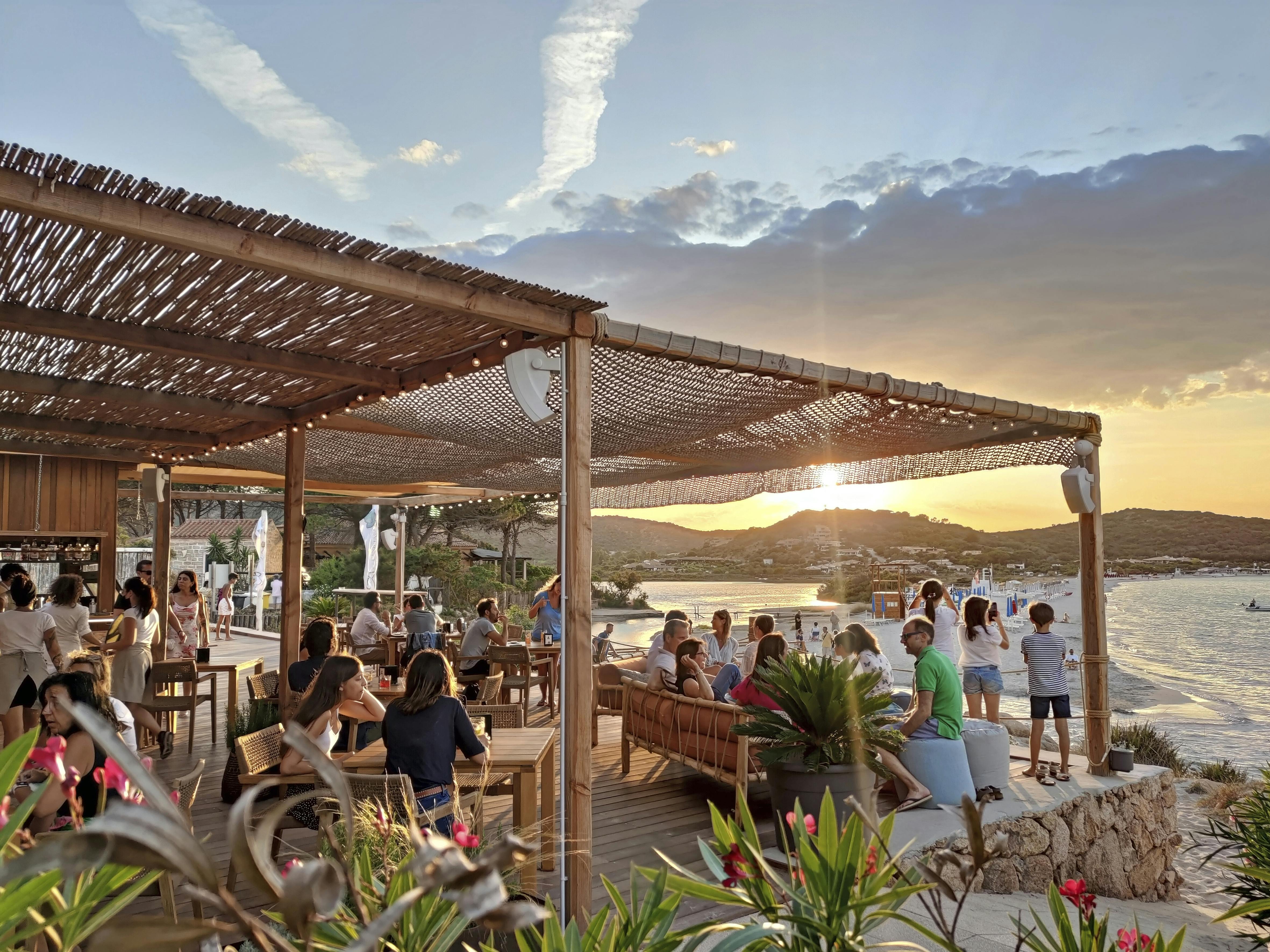 Med den smukkeste solnedgang på menuen. La Tavernetta Beach Bar på stranden Porto Taverna. Sardinien i Italien - restauranten la tavernetta beach bar i porto taverna