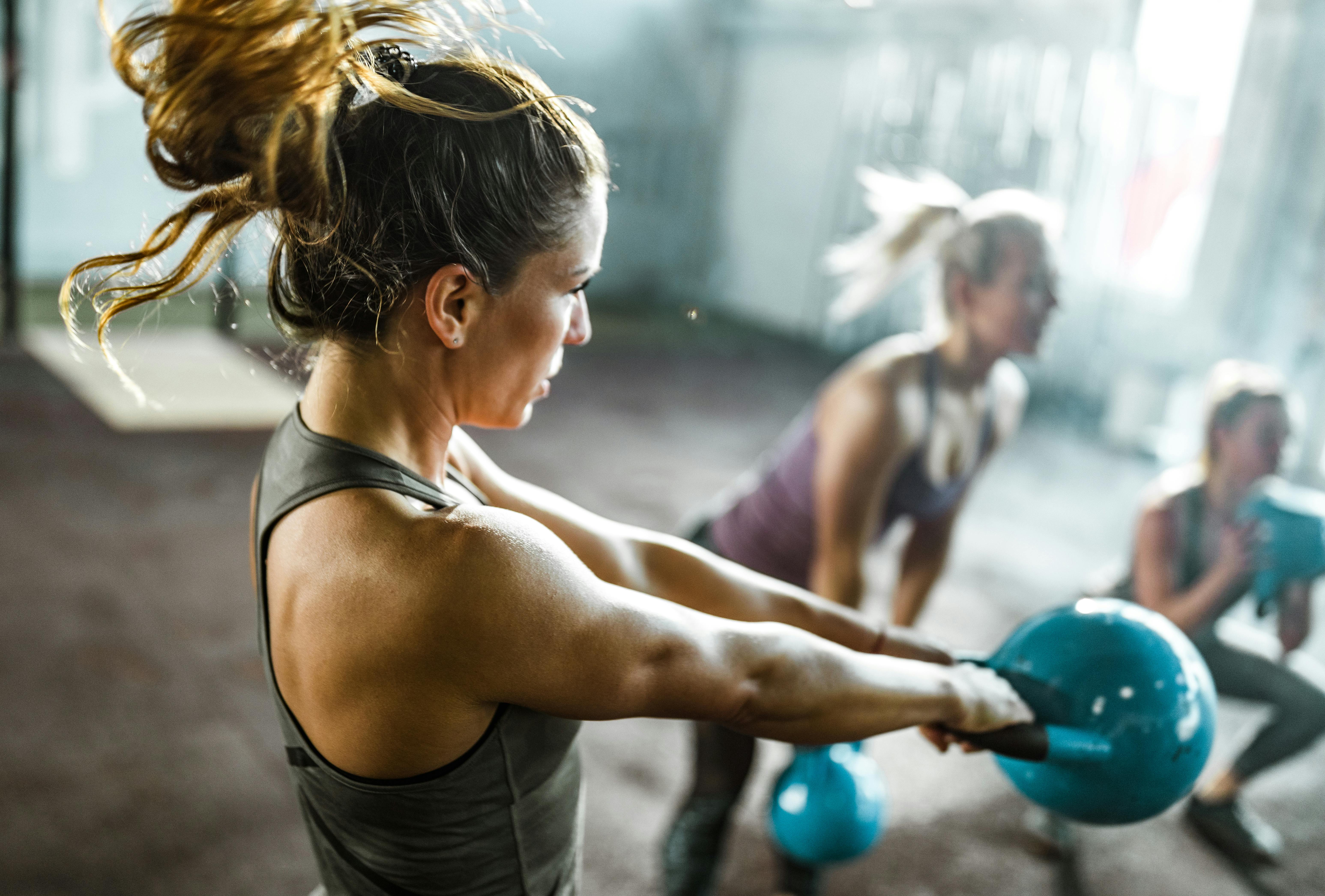 Ved at lytte til en træningspodcast kan du måske undgå nogle fejl, du ikke vidste, du lavede. Kvinde med kettlebell
