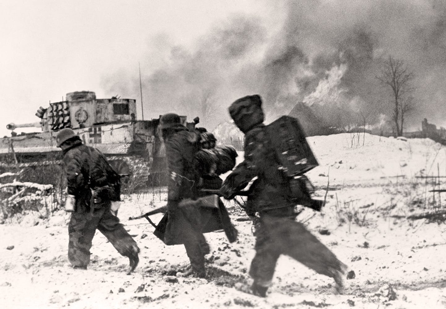 Östfronten 1944. Tyska grenadjärer i snö med utbränd Tiger stridsvagn i bakgrunden.