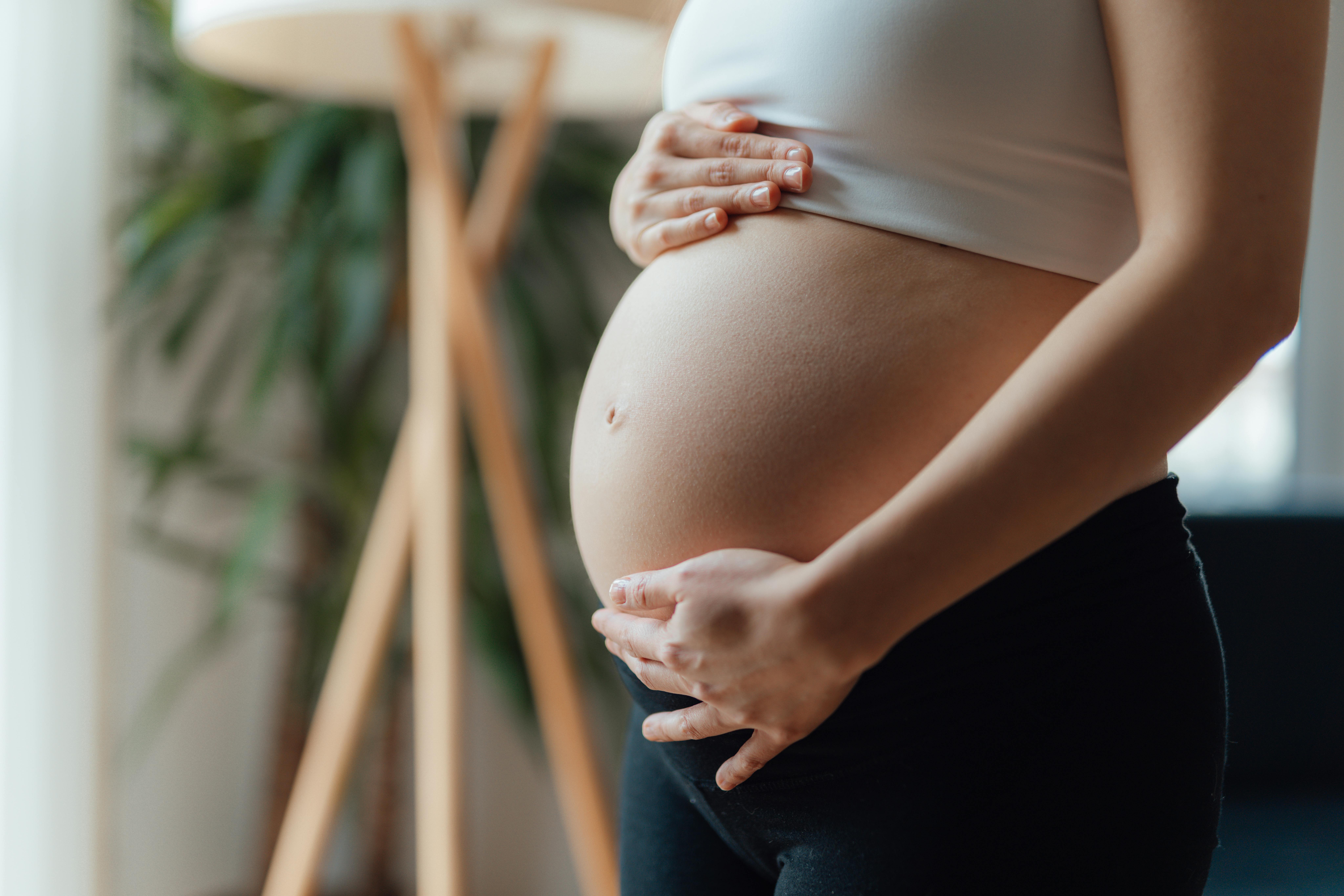Når du er gravid i uge 29, begynder fostrets hjerne at kontrollere åndedrætten. Kvinde, som er gravid i uge 29, rører sin mave