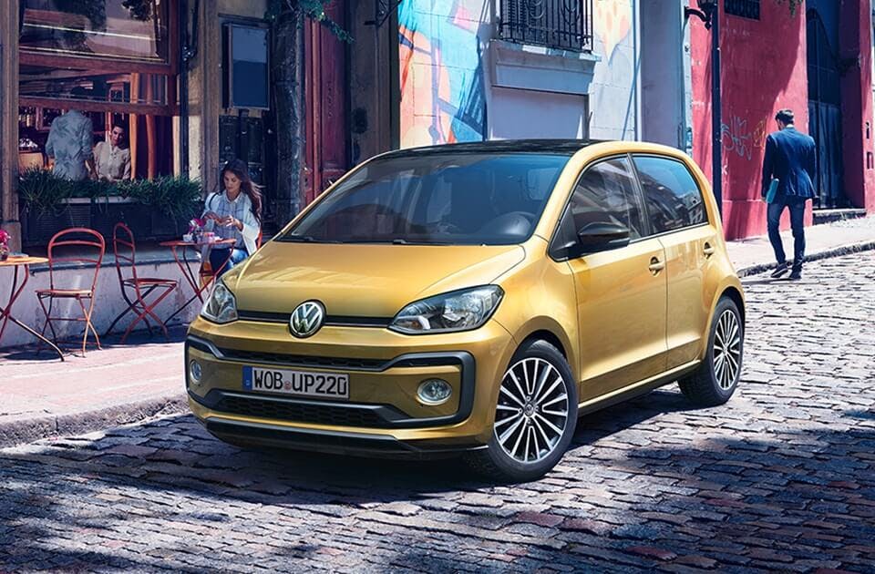 vw up fra folkevogn i guld på gade i byen