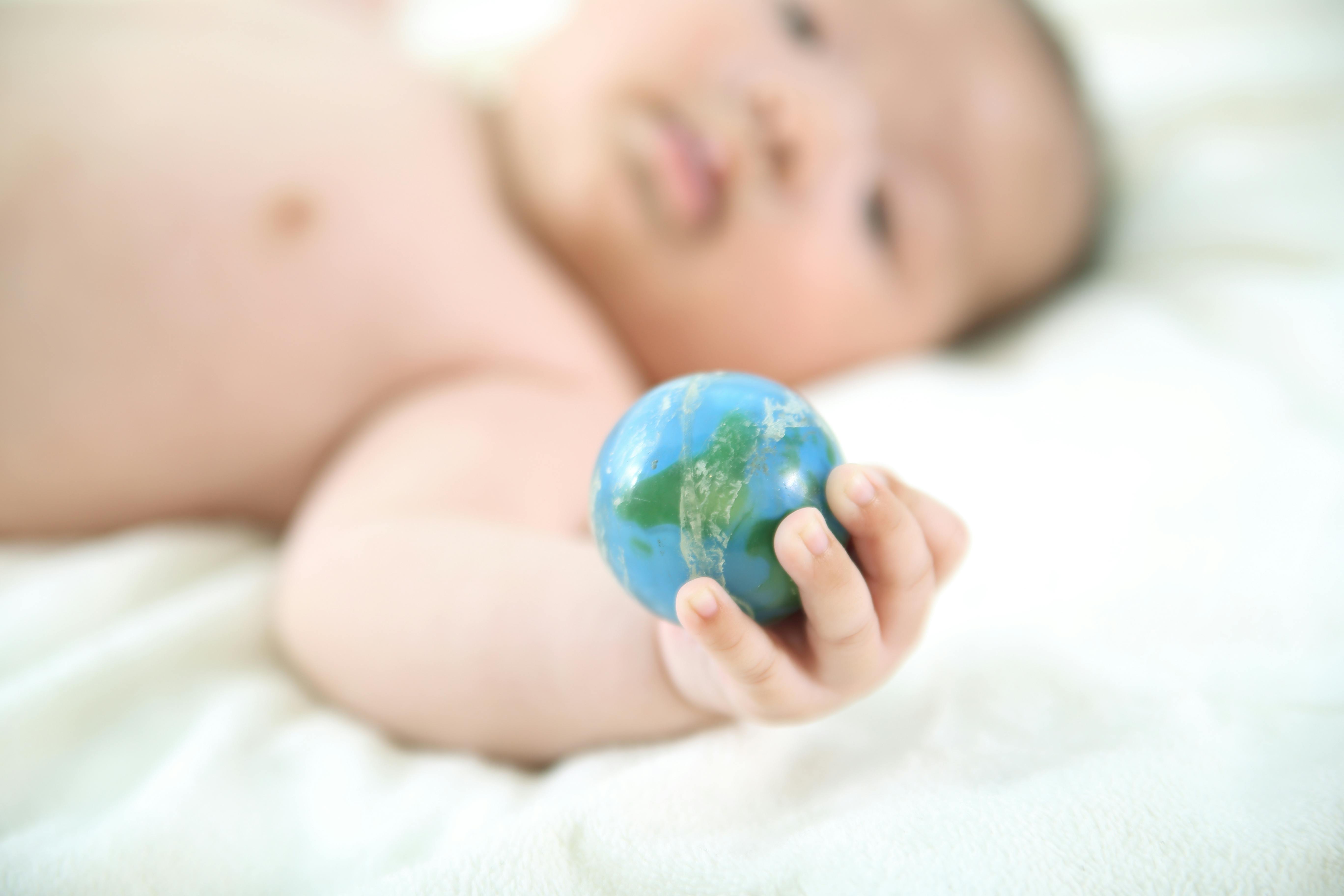 Måske hedder denne lille guldklump Aspen, Mali eller Sydney. Baby med globus