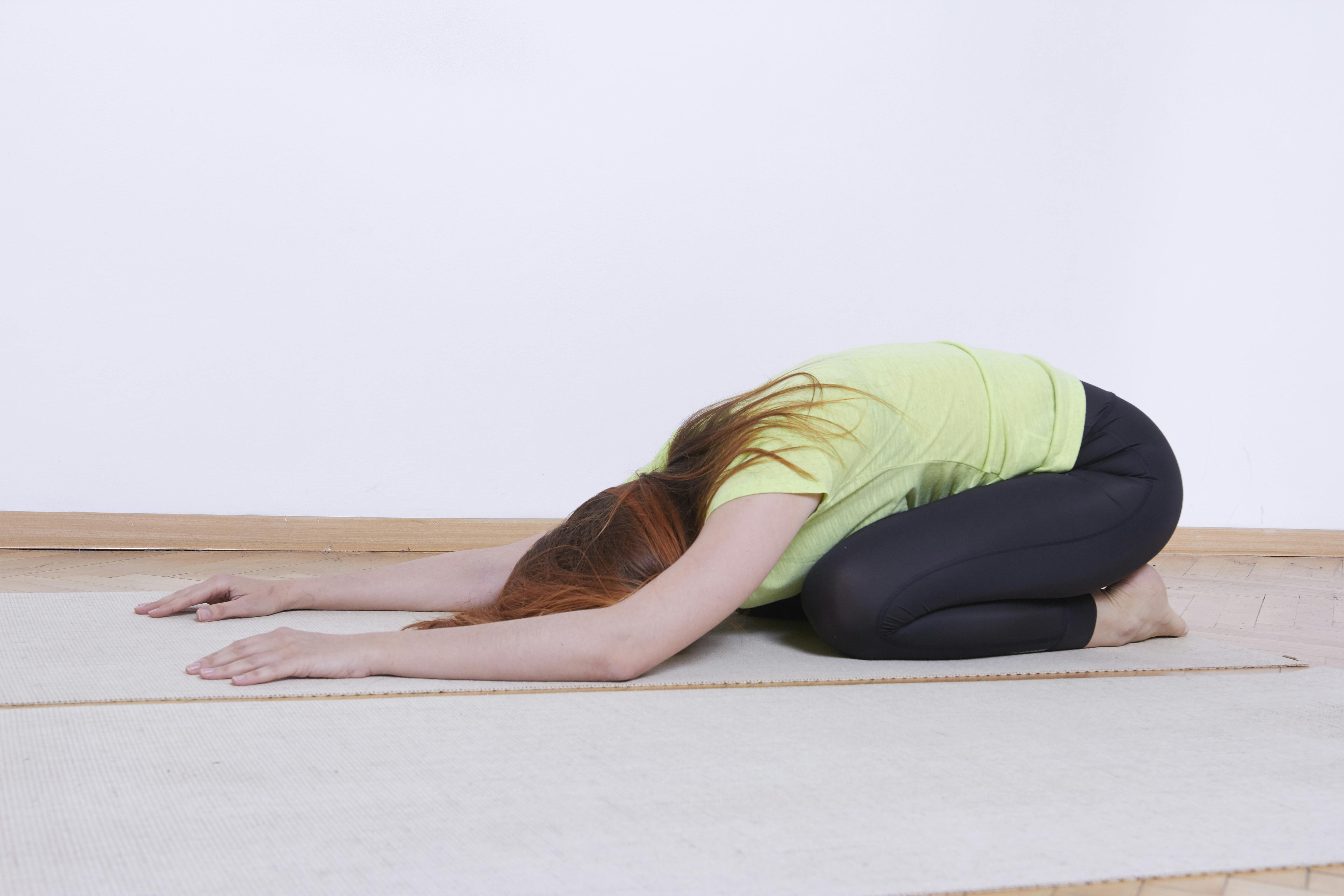Yogastillingen, du skal ned i, hedder Barnet. Og ja, sådan lå de jo, de små. Kvinde laver barnets stilling, yoga